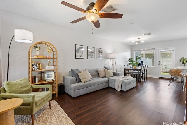 living area featuring dark wood-style flooring, ceiling fan, and visible vents