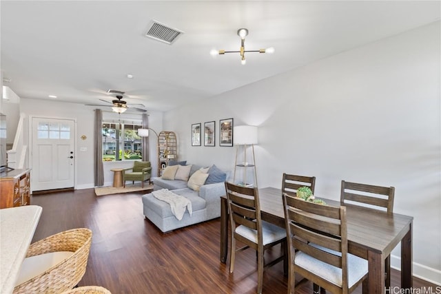 living area featuring visible vents, dark wood-style flooring, and baseboards