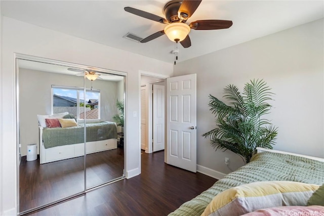 bedroom with a closet, baseboards, visible vents, ceiling fan, and wood finished floors