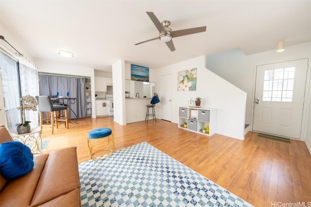 living room featuring light wood-type flooring and a ceiling fan