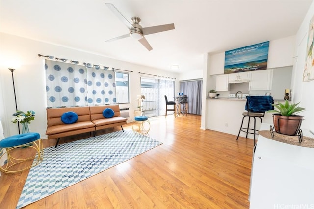 living area with ceiling fan and light wood-type flooring