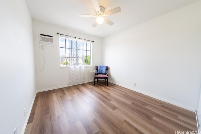 unfurnished room with wood finished floors, a wall mounted air conditioner, baseboards, and radiator heating unit