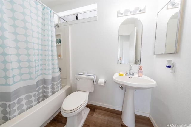 bathroom featuring shower / bath combo, baseboards, a sink, toilet, and wood finished floors