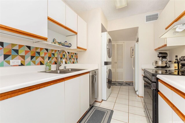 1022 Prospect St Unit 704A, Honolulu, HI 96822 - kitchen featuring black electric range, a sink, stacked washer and clothes dryer, stainless steel dishwasher, and white cabinets