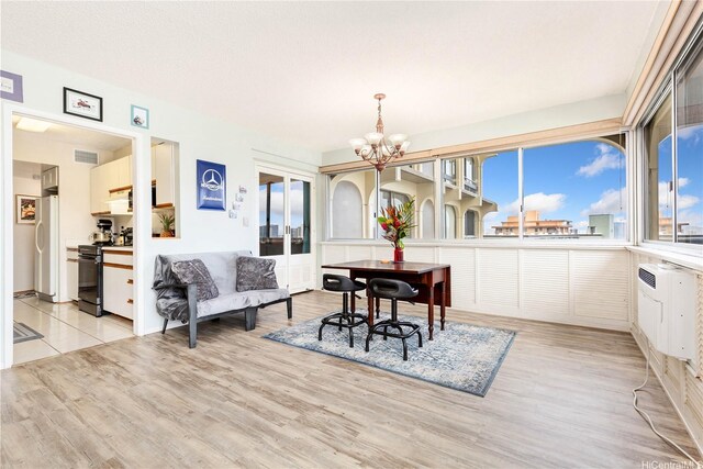 1022 Prospect St Unit 704A, Honolulu, HI 96822 - dining space with a chandelier, light wood-style floors, and an AC wall unit