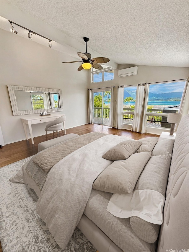 44-313 Kaneohe Bay Dr Unit B, Kaneohe, HI 96744 - bedroom featuring a wall unit AC, a textured ceiling, access to exterior, wood finished floors, and a ceiling fan