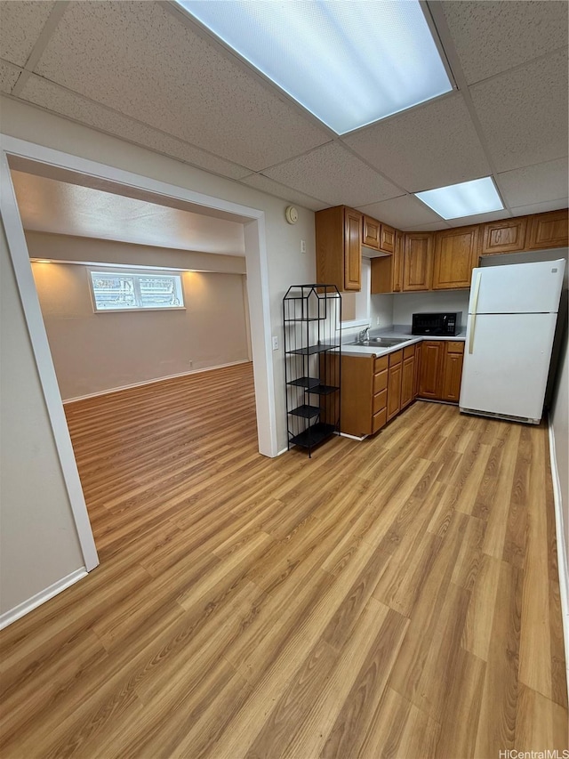 44-313 Kaneohe Bay Dr Unit B, Kaneohe, HI 96744 - kitchen featuring freestanding refrigerator, light wood-type flooring, brown cabinets, light countertops, and a sink