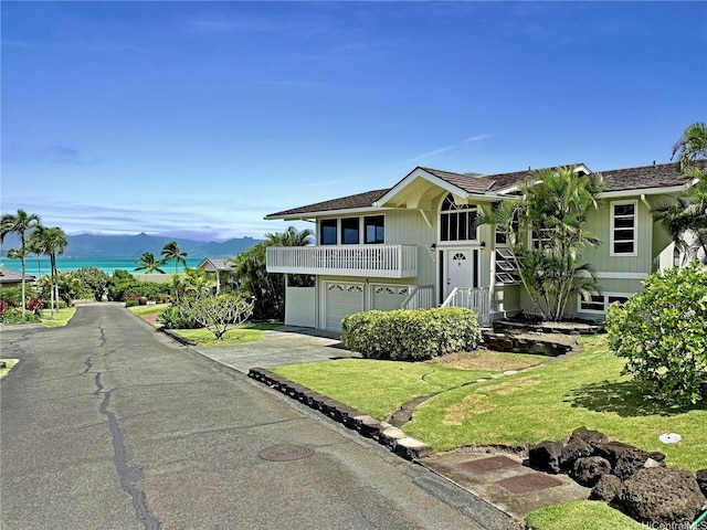 44-313 Kaneohe Bay Dr Unit B, Kaneohe, HI 96744 - view of front of house with asphalt driveway, a balcony, a front yard, and an attached garage