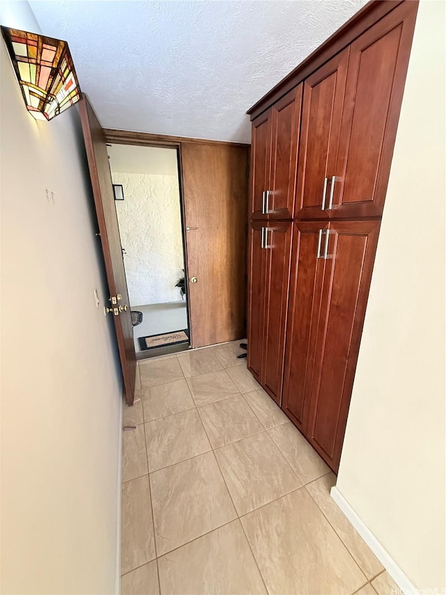 521 Hahaione St Unit 2-15L, Honolulu, HI 96825 - hallway featuring a textured ceiling and light tile patterned flooring