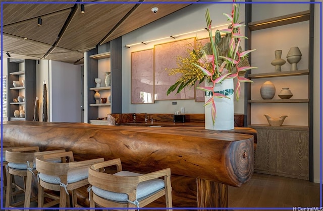 bar with built in features and wood finished floors