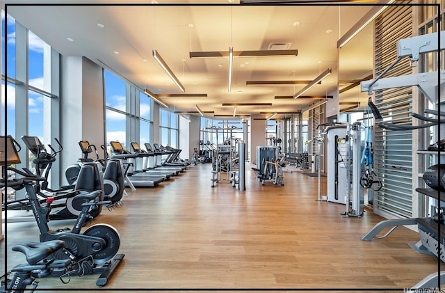 gym with visible vents, wood finished floors, and floor to ceiling windows