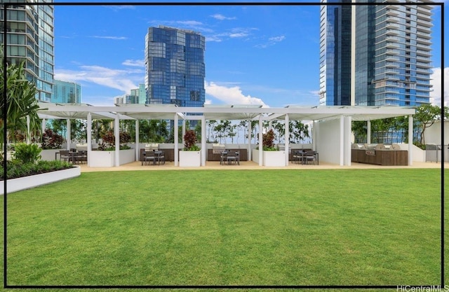 back of house featuring a pergola, a yard, outdoor dining space, and a patio