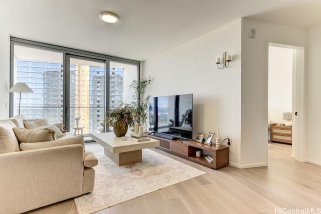 living room with light wood-style flooring, baseboards, and expansive windows