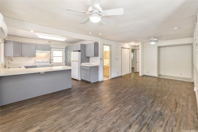 kitchen with gray cabinets, white appliances, a peninsula, a ceiling fan, and a sink