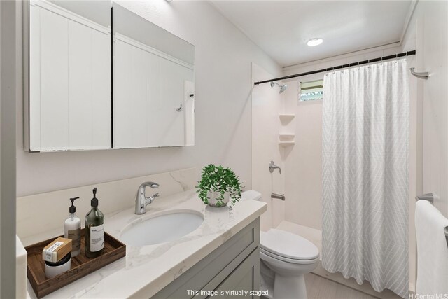 bathroom with toilet, a shower stall, and vanity
