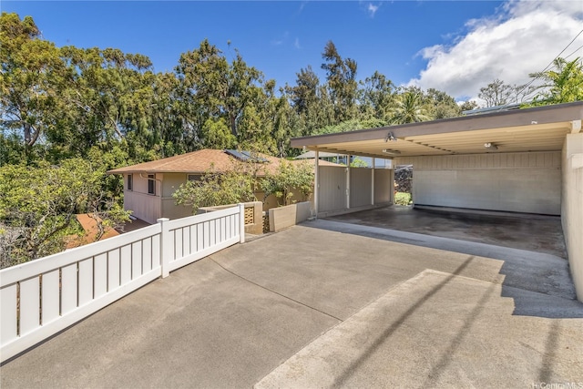 view of side of home with a carport and concrete driveway
