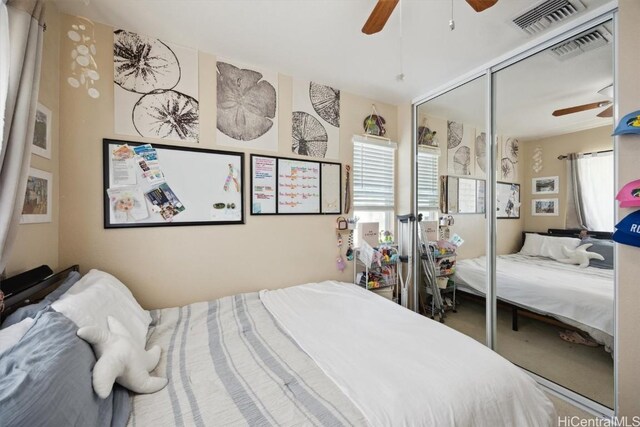 bedroom featuring visible vents, a closet, and multiple windows