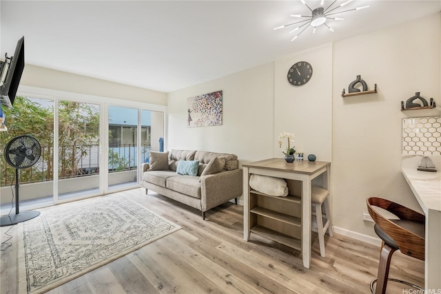 222 Kaiulani Ave Unit 208, Honolulu, HI 96815 - living room featuring an inviting chandelier, baseboards, and light wood finished floors