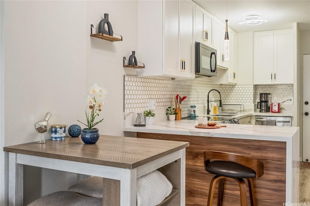 222 Kaiulani Ave Unit 208, Honolulu, HI 96815 - kitchen featuring a breakfast bar area, white cabinetry, black microwave, and tasteful backsplash