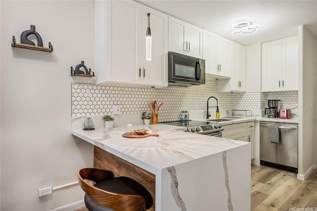 222 Kaiulani Ave Unit 208, Honolulu, HI 96815 - kitchen featuring a sink, stainless steel appliances, white cabinetry, a peninsula, and decorative backsplash