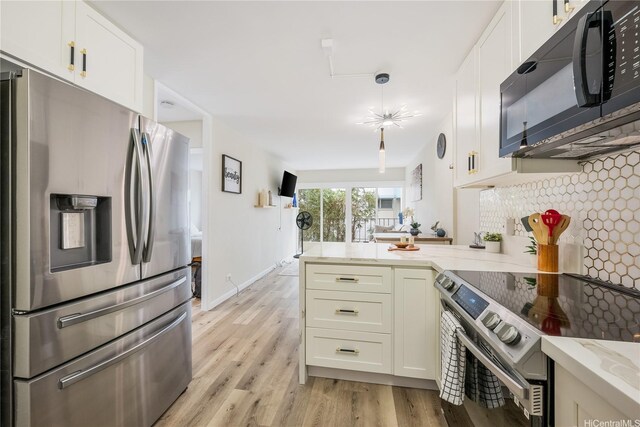 222 Kaiulani Ave Unit 208, Honolulu, HI 96815 - kitchen featuring light stone counters, white cabinets, a peninsula, light wood finished floors, and stainless steel appliances