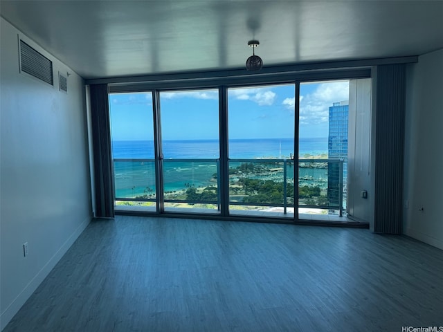 1177 Queen St Unit 3905, Honolulu, HI 96814 - unfurnished room featuring wood finished floors, a water view, baseboards, and expansive windows