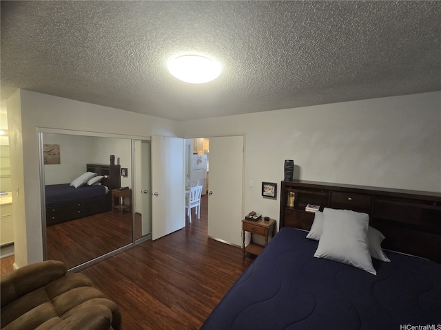 bedroom featuring a closet, wood finished floors, and a textured ceiling