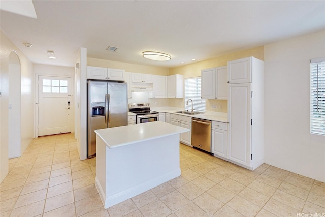 91-1092 Kaileolea Dr, Ewa Beach, HI 96706 - kitchen with appliances with stainless steel finishes, under cabinet range hood, arched walkways, light countertops, and white cabinetry