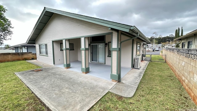rear view of property with fence and a lawn