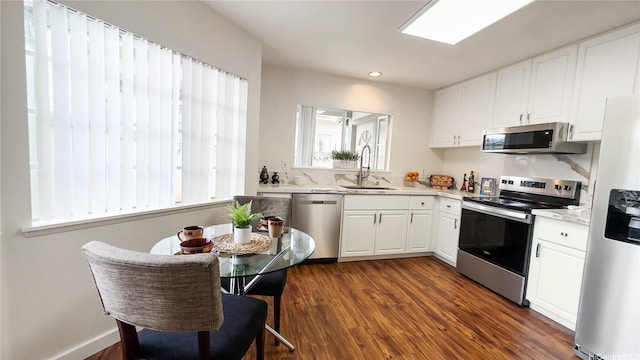 kitchen with light countertops, white cabinetry, a sink, and appliances with stainless steel finishes