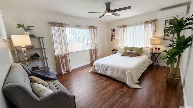 bedroom with wood finished floors, baseboards, and an AC wall unit