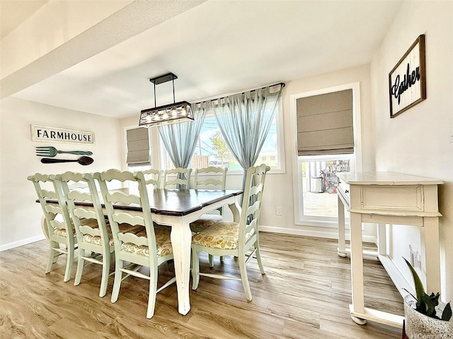 dining room with baseboards and light wood-style flooring