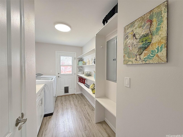 washroom with cabinet space, washing machine and dryer, and light wood finished floors