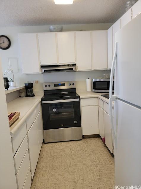 2140 Kuhio Ave Unit 801, Honolulu, HI 96815 - kitchen featuring stainless steel appliances, extractor fan, white cabinetry, and light countertops