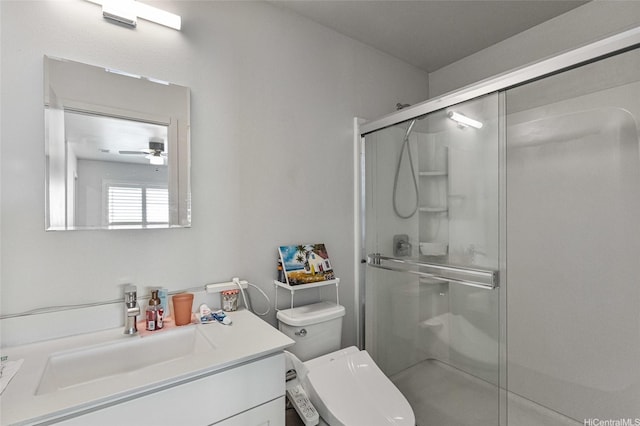 bathroom with a shower stall, ceiling fan, vanity, and toilet
