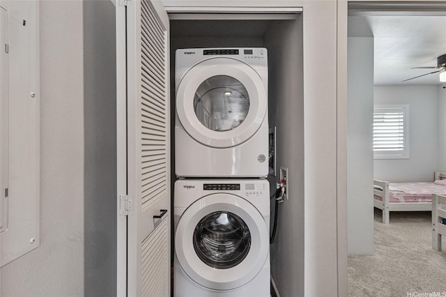 clothes washing area with carpet flooring, laundry area, stacked washer / dryer, and ceiling fan