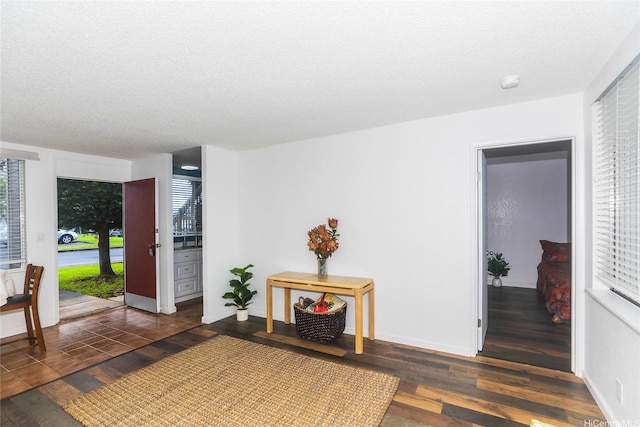 interior space with dark wood finished floors, baseboards, and a textured ceiling
