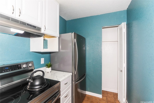 kitchen with baseboards, white cabinets, under cabinet range hood, light stone countertops, and appliances with stainless steel finishes