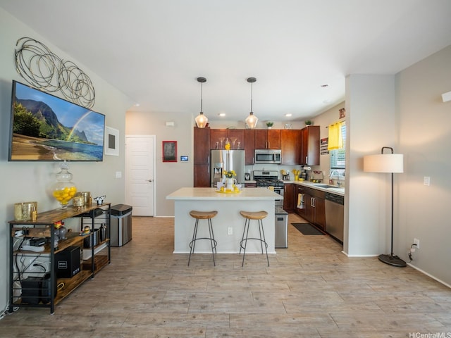 91-1483 Loiloi Loop, Ewa Beach, HI 96706 - kitchen with appliances with stainless steel finishes, light countertops, a breakfast bar area, a sink, and decorative light fixtures