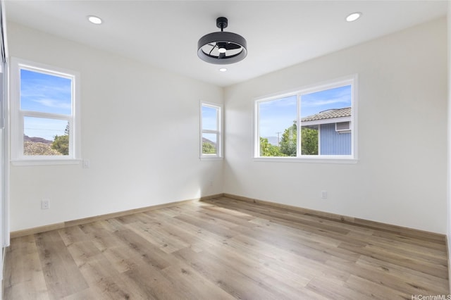 spare room with recessed lighting, light wood-style floors, and baseboards