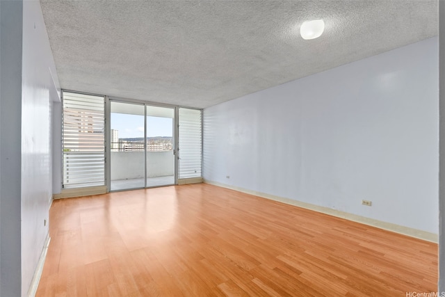 1031 Ala Napunani St Unit 401, Honolulu, HI 96818 - spare room with a textured ceiling, baseboards, and light wood-type flooring
