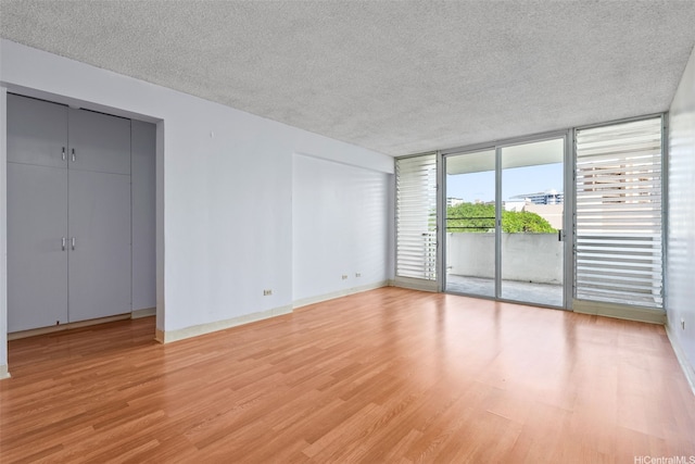 1031 Ala Napunani St Unit 401, Honolulu, HI 96818 - interior space with access to exterior, light wood-type flooring, floor to ceiling windows, and a textured ceiling