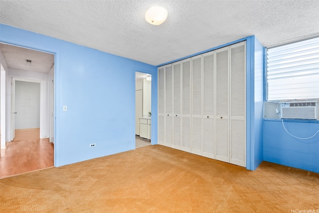 1031 Ala Napunani St Unit 401, Honolulu, HI 96818 - unfurnished bedroom featuring cooling unit, carpet, a textured ceiling, and a closet