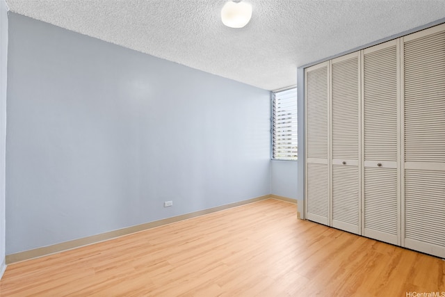 1031 Ala Napunani St Unit 401, Honolulu, HI 96818 - unfurnished bedroom with baseboards, wood finished floors, a textured ceiling, and a closet