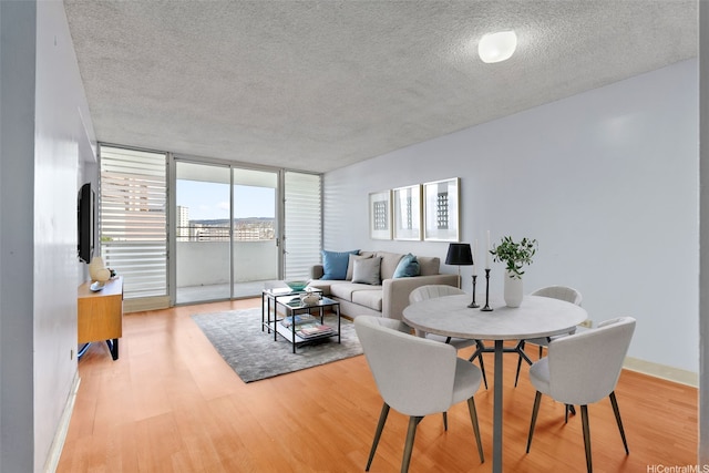 1031 Ala Napunani St Unit 401, Honolulu, HI 96818 - dining room with light wood-style flooring, baseboards, a textured ceiling, and floor to ceiling windows