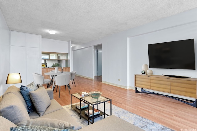 1031 Ala Napunani St Unit 401, Honolulu, HI 96818 - living area with light wood-type flooring, a textured ceiling, and baseboards