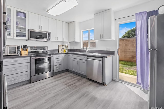 91-1163 Kamaaha Loop Unit 13C, Kapolei, HI 96707 - kitchen with a sink, appliances with stainless steel finishes, dark countertops, and white cabinetry