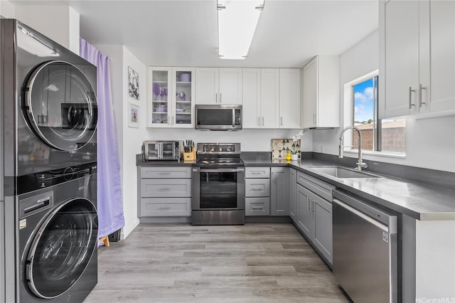 91-1163 Kamaaha Loop Unit 13C, Kapolei, HI 96707 - kitchen featuring light wood-style floors, white cabinets, stacked washer / dryer, appliances with stainless steel finishes, and a sink