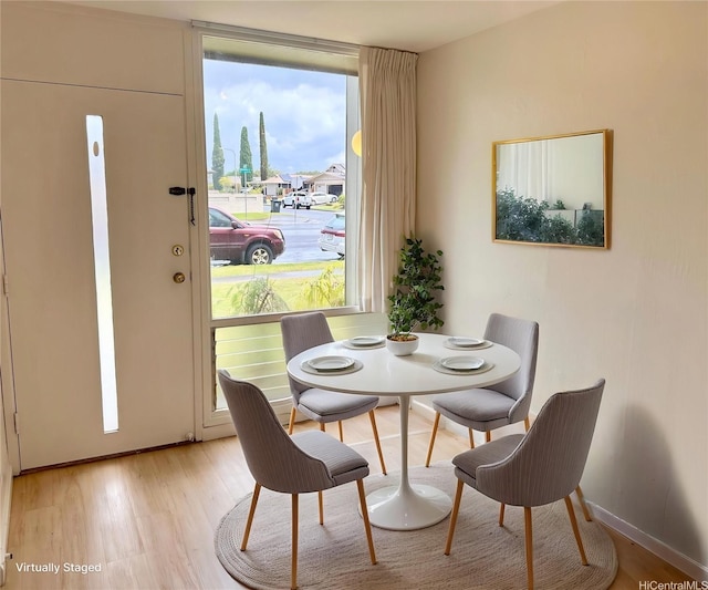 dining area with light wood-style floors and baseboards
