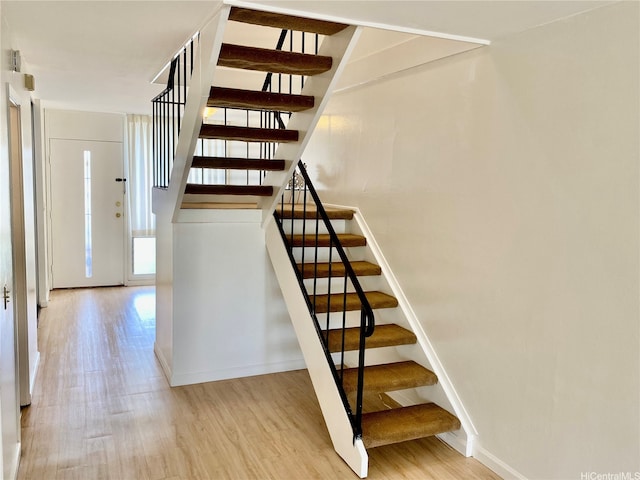 stairs featuring wood finished floors and baseboards